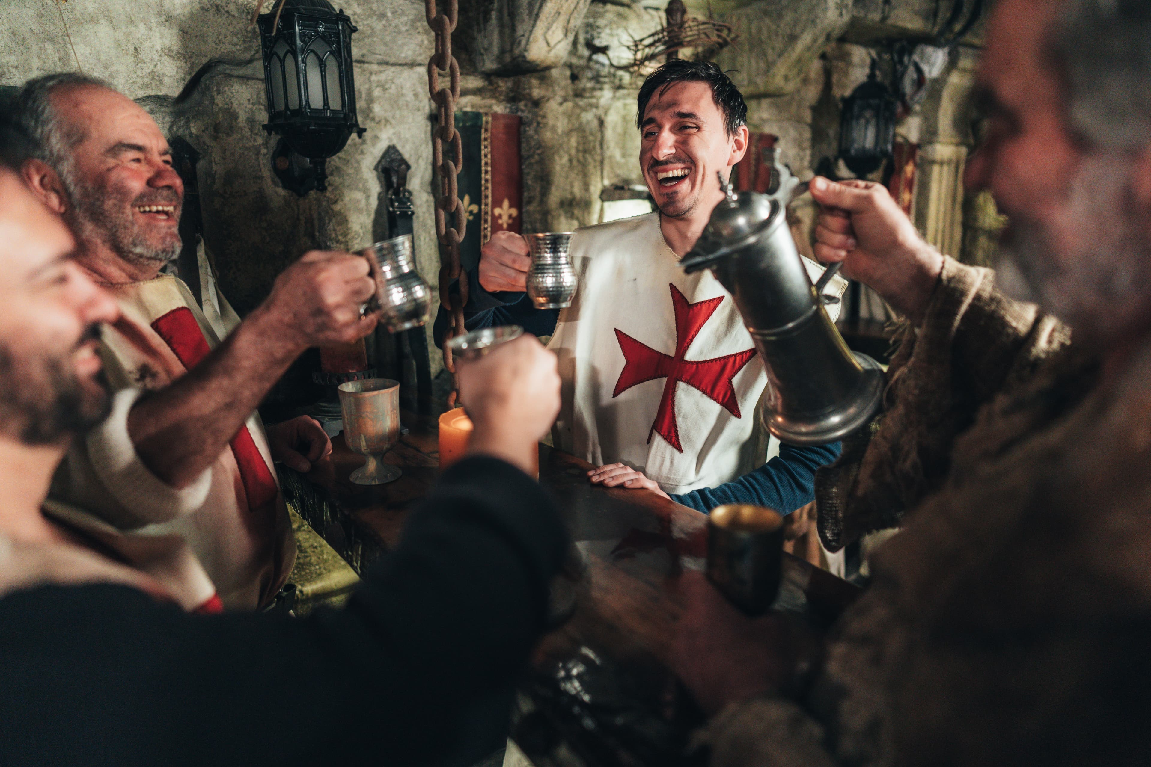 Colleagues laughing and raising a toast in the medieval bar